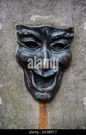 Masque de bronze avec un visage heureux sur la tête de puits à l'extérieur de l'Edinburgh Fringe Office sur le Royal Mile, Edimbourg, Ecosse, Royaume-Uni. Banque D'Images