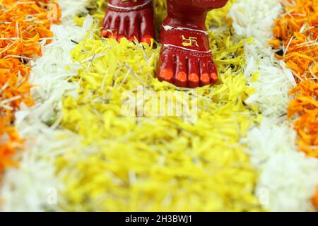 Shubh Deepawali et Laxmi Pooja - pieds rouges Charan ongles peints de la déesse hindoue Mata Lakshmi.Marcher ou venir poser sur Marigold Flower Bed Rangol Banque D'Images