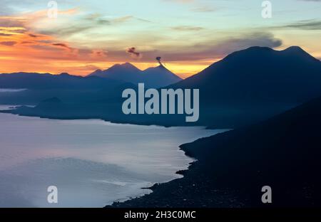 Lever du soleil au-dessus du lac Atitlan et de Fuego, volcan, Lago Atitlan, Guatemala Banque D'Images