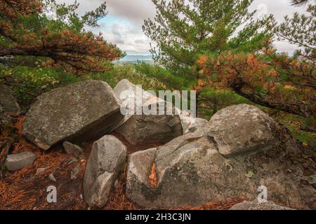 Flanc de coteau rocheux sur la montagne dans le Massachusetts le jour nuageux en automne avec feuillage d'automne pendant la saison d'octobre regardant au-dessus de la vallée Banque D'Images