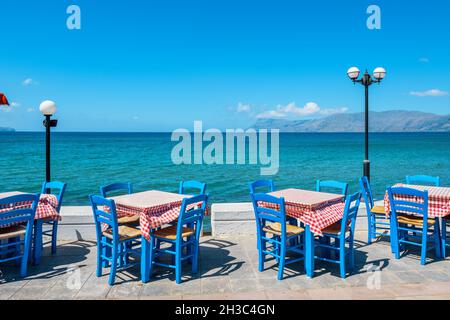 Tables avec chaises dans la taverne grecque traditionnelle de la ville de Kissamos sur la côte de l'île de Crète. Grèce Banque D'Images