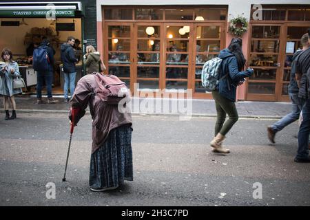 Londres, Royaume-Uni - 20 novembre 2020, Une mendiante marche à travers la foule en suppliant pour des almes. Banque D'Images