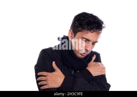 Homme très froid portant une veste et un foulard, isolé sur fond blanc.Les jeunes adultes ne peuvent pas supporter autant de froid. Banque D'Images