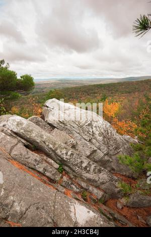 Flanc de coteau rocheux sur la montagne dans le Massachusetts le jour nuageux en automne avec feuillage d'automne pendant la saison d'octobre regardant au-dessus de la vallée Banque D'Images