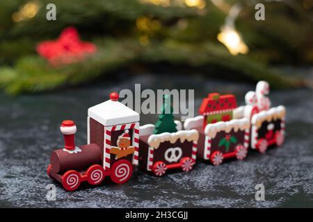 Train pour enfants en bois sur fond de branches d'arbres de Noël. Banque D'Images