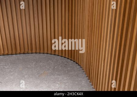 Combinaison mur en bois nervuré et sol en pierre.Panneau texturé en bois et carrelage en pierre grise.Design intérieur en coin rond. Banque D'Images