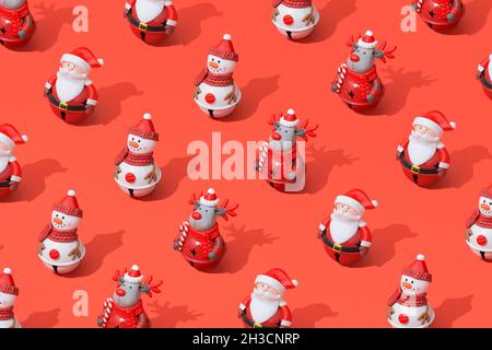 Composition de motifs de jouets de Noël sur fond rouge avec ombres dures Banque D'Images