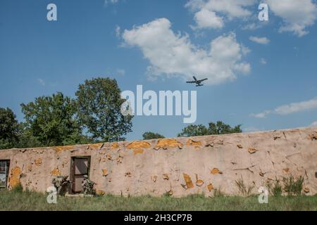 Les sceaux de la marine américaine gardent l'entrée d'un complexe tandis qu'un A-10 Thunderbolt II vole au-dessus pendant Sentry Rescue IV, une initiative de commandement conjoint visant à développer des tactiques, des techniques et des procédures pour les scénarios de récupération du personnel, Arkansas, 26 août 2021.Les forces terrestres, qui comprenaient des aviateurs de guerre spéciale du 146e Escadron des opérations de soutien aérien, ont été appuyées par Des A-10 de la base aérienne de Whiteman, au Missouri.(É.-U.Photo de la Garde nationale aérienne par Tech.Sgt.Brigette Waltermire) Banque D'Images