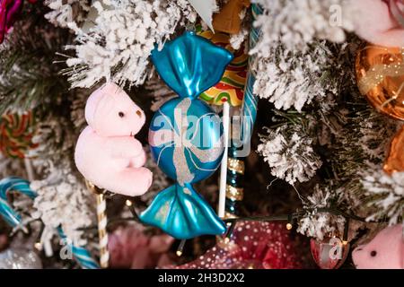 Carte de Noël, l'humeur du nouvel an différents jouets de noël accrochés à l'arbre. Joli fond de noël avec une mise au point sélective. Boules de bonbons suspendues et autres Banque D'Images