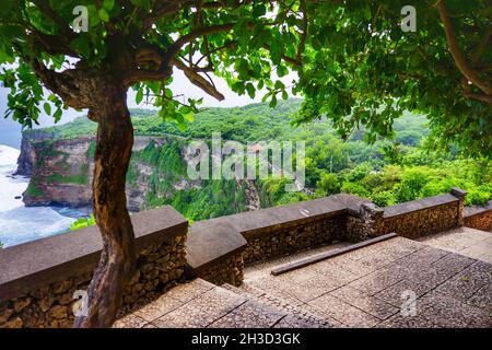 Vue sur une passerelle vers le temple d'Uluwatu au bord de la mer bleue et sur la plage de Bali, en Indonésie.Personne.Pour le tourisme de voyage concept et de fond. Banque D'Images