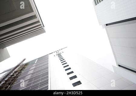 Complexe urbain moderne avec gratte-ciel et édifices blancs de hauteur moyenne.Vue à angle bas. Banque D'Images