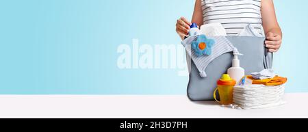 Bannière.Femme emballage sac couches bleu. Banque D'Images