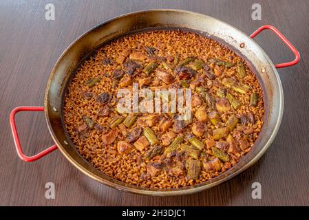 Paella espagnole de champignons boletus aux asperges sauvages, riz socarrat servi dans sa poêle à paella Banque D'Images