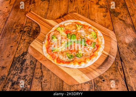 Petite pizza à croûte mince avec légumes.Branches de brocoli, fines tranches d'aubergine, tomates cerises et fromage mozzarella Banque D'Images