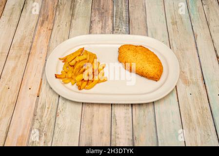 Assiette de schnitzel de poulet farci de fromage et de jambon avec chapelure frite dans de l'huile d'olive avec une garniture de frites Banque D'Images