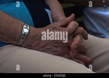 femme âgée les mains se replient sur les genoux Banque D'Images