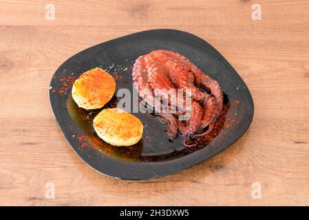 Poulpe cuite galicienne avec des pommes de terre, de l'huile d'olive, du paprika de la Vera et du sel de mer Banque D'Images