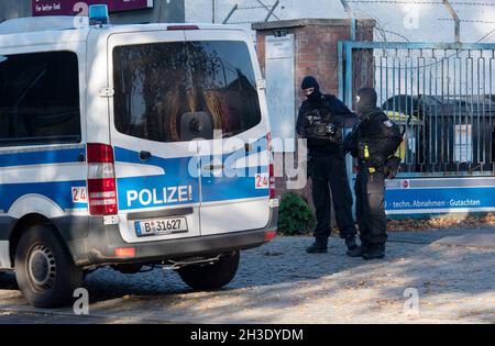 28 octobre 2021, Berlin: Des policiers se tiennent à l'entrée d'un parc industriel à Weißensee.Depuis le début de la matinée, des policiers ont pris des mesures contre les Hells Angels à Berlin et dans le Brandebourg.Plusieurs centaines d'officiers sont impliqués dans le raid.Selon les autorités, l'enquête porte sur le trafic de drogues et le trafic d'armes.Les preuves telles que les supports de données, les téléphones cellulaires et les actifs sont la cible des recherches.Le raid a été déclenché par des données déchiffrées du service de messagerie court Encrochat.Photo: Paul Zinken/dpa - ATTENTION: Nom(s) de la société ont été pixelate Banque D'Images