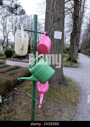 arrosoirs suspendus dans un cimetière Banque D'Images