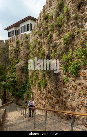 Escaliers entre les murs de pierre avec lierre suspendue descendant vers une plage d'Antalya en Turquie Banque D'Images