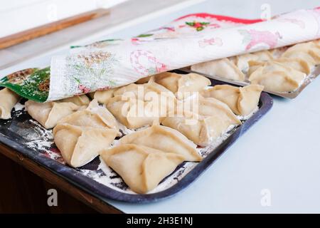 Manti cru sur une plaque de cuisson. Un plat de pâte et de viande hachée préparé pour la cuisson à la vapeur Banque D'Images