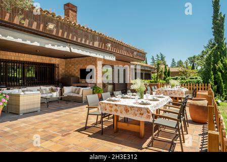 Tables à manger disposées pour un déjeuner d'entreprise sur une terrasse d'un chalet dédié à la coworking Banque D'Images