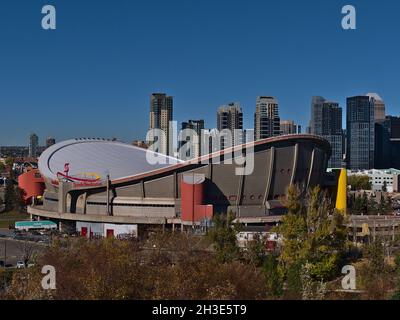 Vue sur l'arène intérieure moderne et polyvalente Scotiabank Saddledome dans le Stampede Park, à Calgary, le jour ensoleillé de la saison d'automne avec vue sur la ville en arrière-plan. Banque D'Images