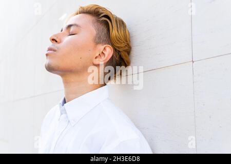 Anonyme femme ethnique surprise avec bouche ouverte explorant la réalité virtuelle dans le casque sur fond noir Banque D'Images