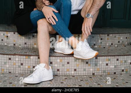 Un jeune couple ethnique anonyme s'embrassant tandis qu'il est assis ensemble dans les escaliers de la rue Banque D'Images