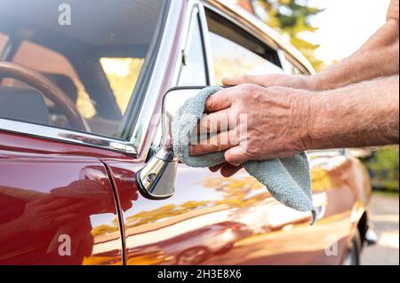 ILLUSTRATION - Un homme nettoie son ancien chrono de la marque Peugeot 504 coupé le 15 octobre 2021 à Eckernfoerde avant les vacances d'hiver (scène posée).Photo : Benjamin Nolte || approbation du modèle disponible Banque D'Images
