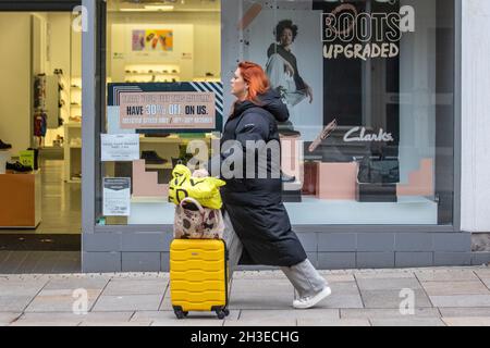 Les acheteurs qui passent devant le magasin de chaussures Clarks « Boots upgraded », font leurs courses avec les affiches de vente de chaussures d'automne, à Fishergate, Preston, Royaume-Uni Banque D'Images