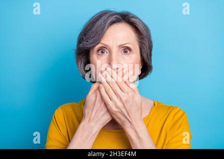 Portrait en gros plan d'une femme d'âge moyen, inquiète et attirante, qui ferme la bouche, isolée sur un arrière-plan bleu vif Banque D'Images