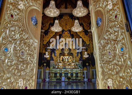 Lampang, Thaïlande - 04 septembre 2019 : en regardant à travers la belle porte du temple d'architecture de l'image dorée de bouddha dans Wat Phra que Doi Phra Cha Banque D'Images