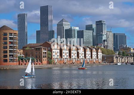 Voile depuis le centre de sports nautiques du Groenland Dock sur le Groenland Dock, qui fait partie des anciens Surrey Docks à Rotherhithe, Londres, Royaume-Uni.Canary Wharf au-delà. Banque D'Images