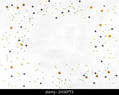 Composition de Noël.Confettis dorés et paillettes noires sur fond blanc.Noël, nouvel an, concept de vacances.Flat lay, vue de dessus Banque D'Images