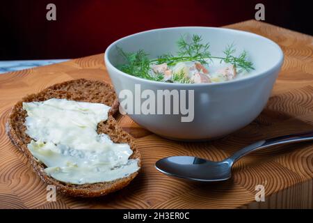 Helsinki / Finlande - 28 OCTOBRE 2021 : cuisine finlandaise traditionnelle : bol de soupe crémeuse au saumon avec garniture à l'aneth.Deux morceaux de pain de seigle sur le côté. Banque D'Images