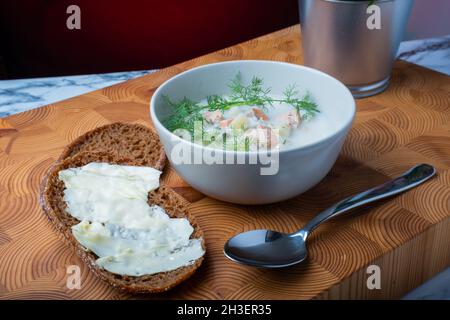 Helsinki / Finlande - 28 OCTOBRE 2021 : cuisine finlandaise traditionnelle : bol de soupe crémeuse au saumon avec garniture à l'aneth.Deux morceaux de pain de seigle sur le côté. Banque D'Images