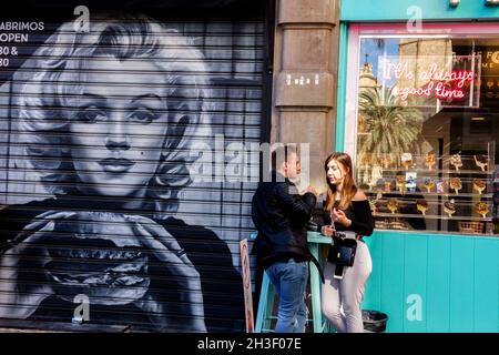 Graffiti Valencia Street art Espagne couple devant un bar dans la vieille ville de Valence Espagne rue scène Banque D'Images