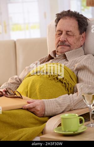 Senior man sleeping in armchair Banque D'Images