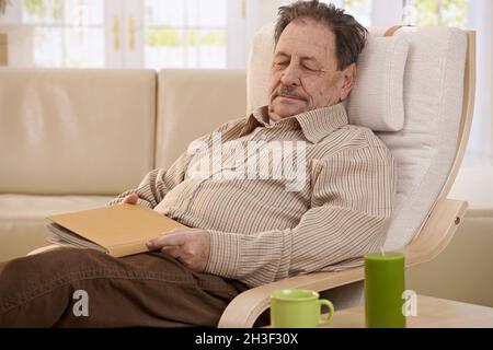 Senior man sleeping in armchair Banque D'Images