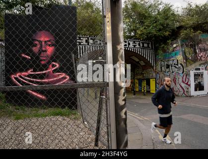 Les gens qui marchent et font du vélo après un pont de train avec des graffitis à Shoreditch, Londres, Angleterre, Royaume-Uni Banque D'Images