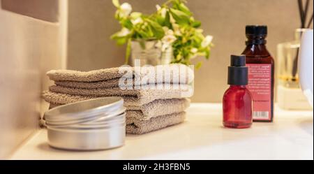 Les bouteilles d'huile et les serviettes sont pliées sur la table.Produits naturels sains faits maison pour les soins du corps et du visage.Décoration moderne à l'intérieur du spa. Banque D'Images