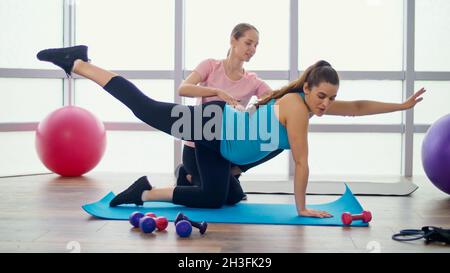 Femme enceinte faire des exercices pour les femmes enceintes avec un entraîneur personnel Banque D'Images
