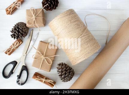 Emballage écologique cadeaux en papier kraft sur fond de bois clair.Noël zéro déchet concept. Banque D'Images