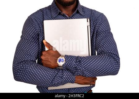 un homme d'affaires charmant debout sur un arrière-plan blanc tenant un ordinateur portable Banque D'Images