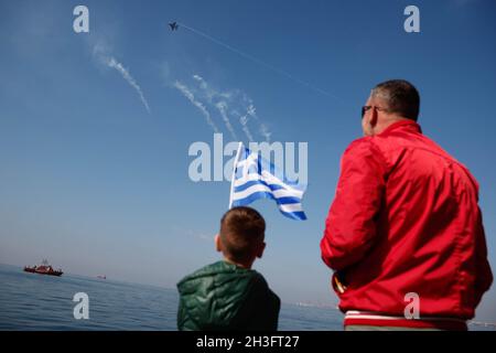 Thessalonique, Grèce.28 octobre 2021.Un garçon avec un drapeau grec regarde un avion militaire lors d'un défilé militaire à Thessalonique, dans le nord de la Grèce, le 28 octobre 2021.Dans le cadre des restrictions de la COVID-19, en particulier dans la partie nord du pays, la Grèce a célébré jeudi le 'Ochi (No) Day' annuel avec des défilés militaires et étudiants.Credit: Dimitris Tosidis/Xinhua/Alamy Live News Banque D'Images