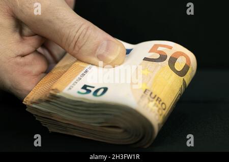 Main tenant un paquet de 50 billets en euros Banque D'Images