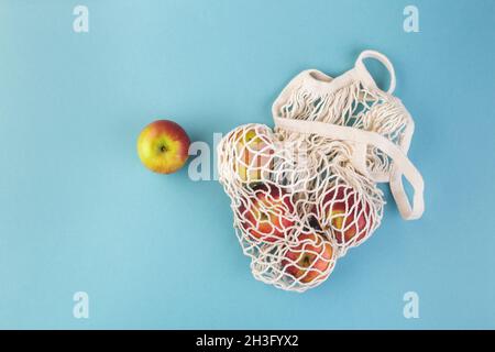 Sac de pomme rouge et de ficelle sur une table bleue.Saison d'été ou d'automne.Concept d'éco-achat Banque D'Images