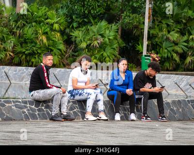 Medellin, Antioquia, Colombie - décembre 22 2020 : amis assis dans une fontaine dans un parc public Banque D'Images