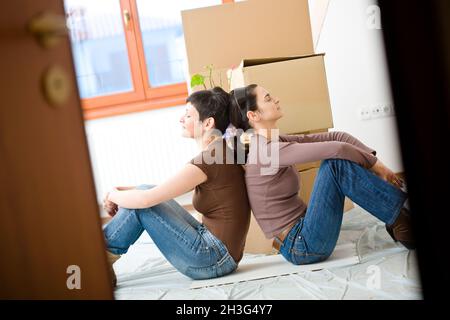 Jeunes femmes qui déménatrent chez elles Banque D'Images